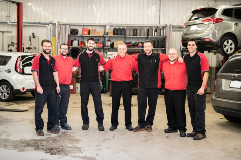 Evo Auto Locksmith team standing together inside an auto workshop
