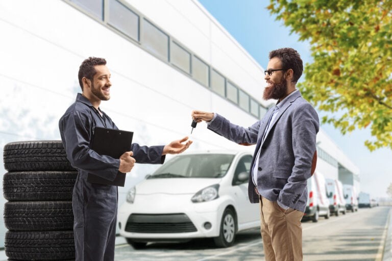 Customer receiving car keys from an auto locksmith technician