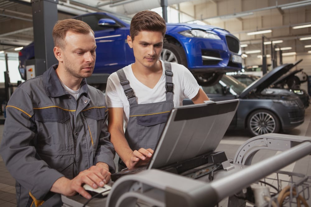 Auto locksmith technicians programming vehicle keys using diagnostic equipment